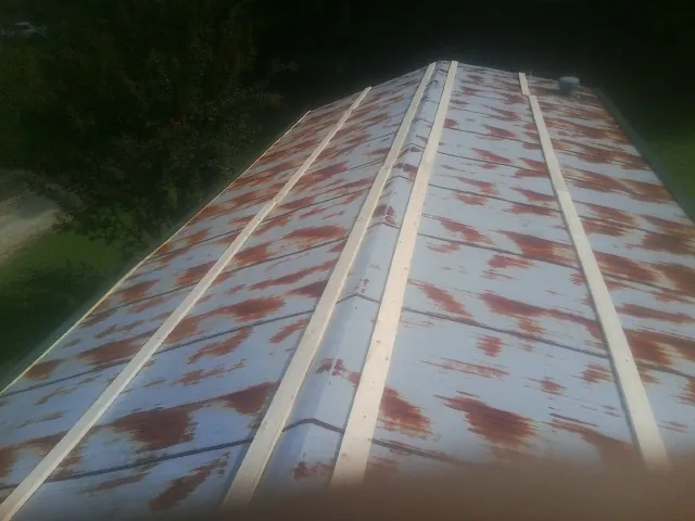 Rusted metal roof panels with new wood purlins before replacement — Storm Damage Roof Repair in North Salem by Roofing Brothers
