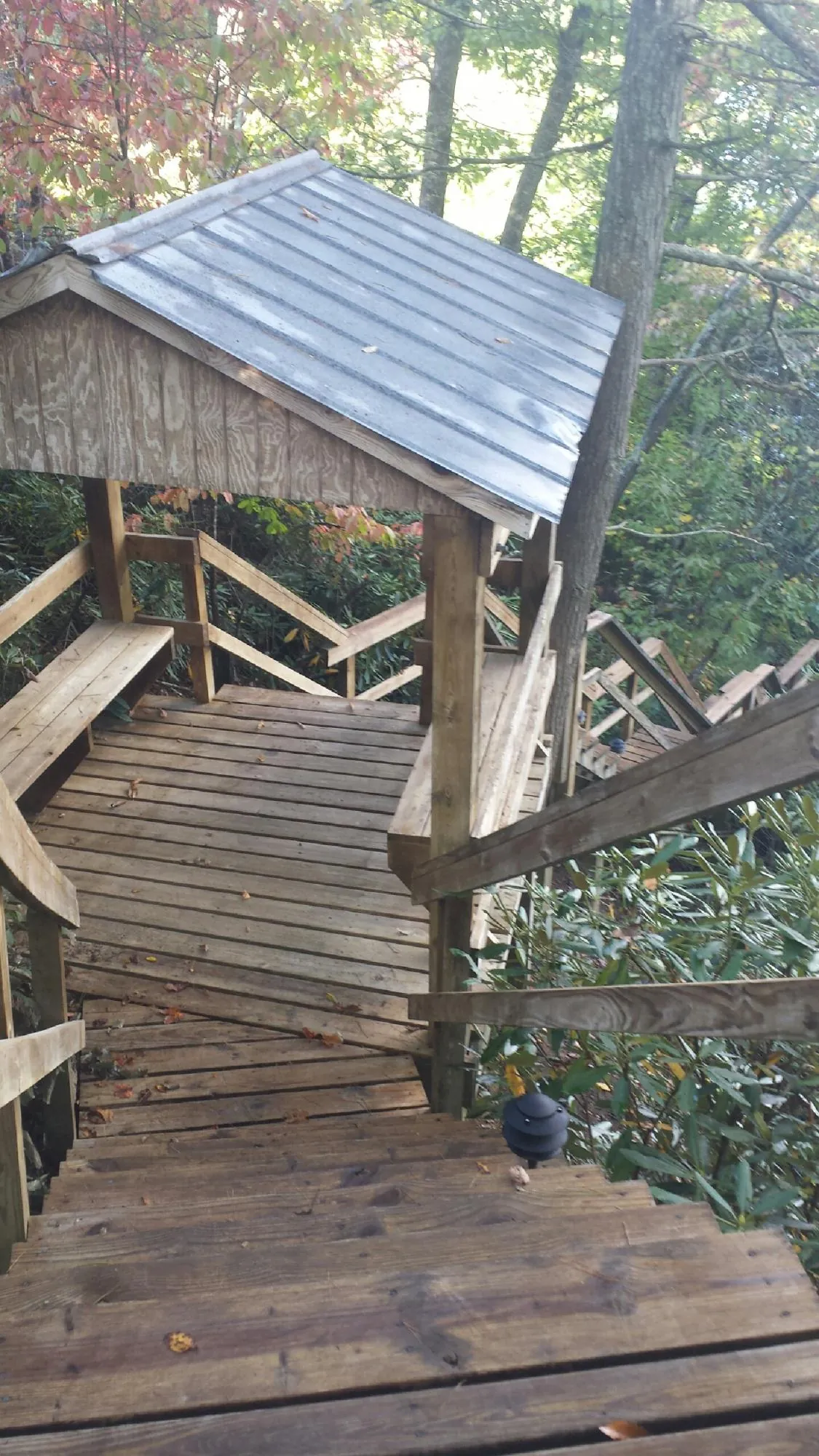 Metal roofed shelter over wooden steps on a wooded walkway — Skylight Repair & Installation work by our crew in North Salem